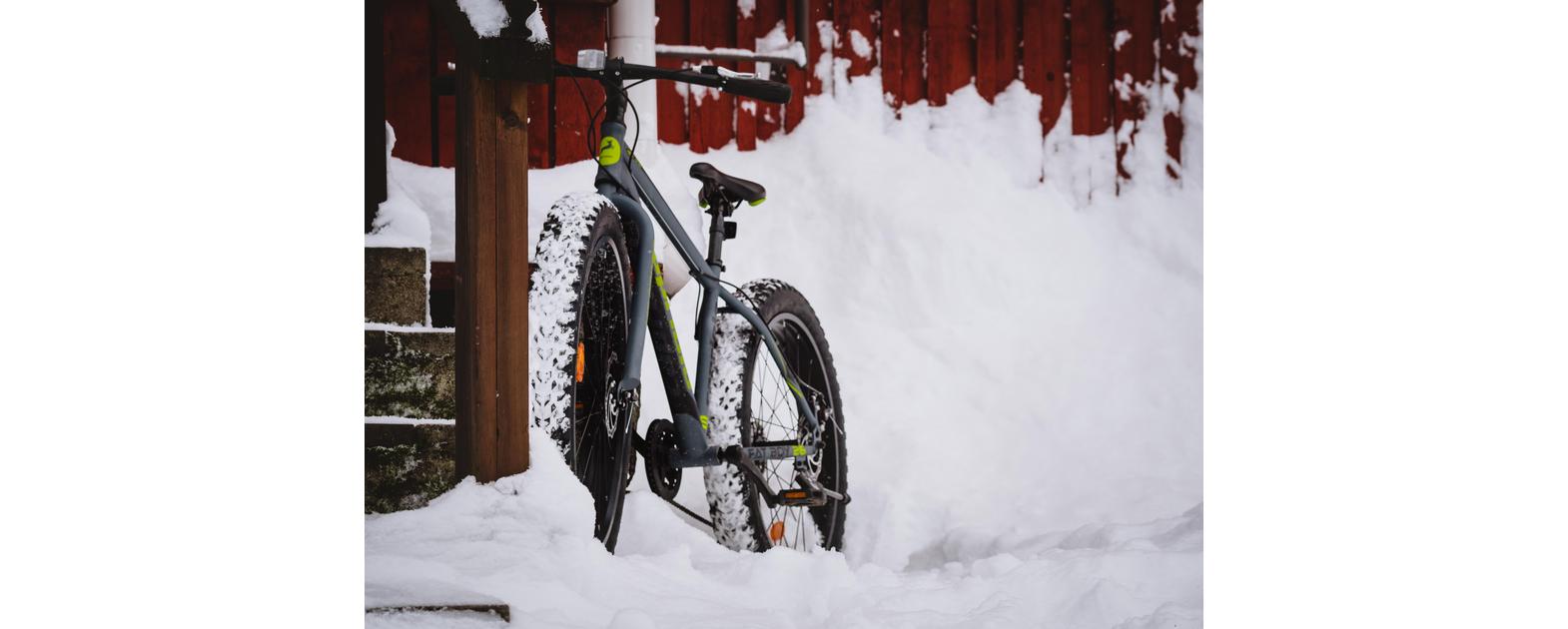 Fatbike nojaa seinää vasten talvella