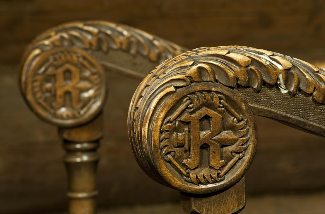 Rajakenraalin tunnus tuolin käsinojassa