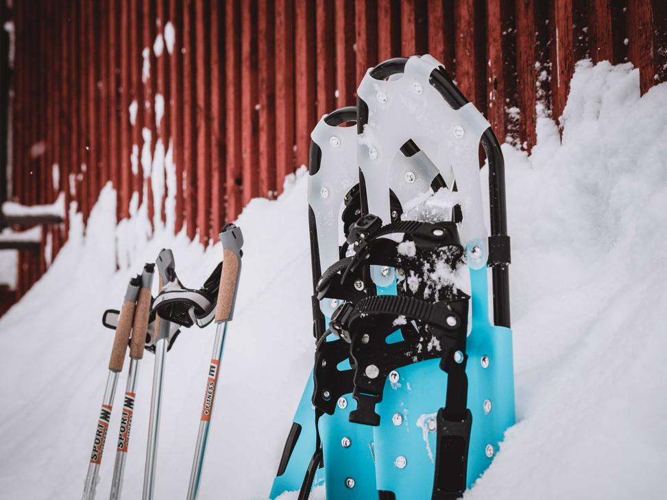 Lumikengät ja sauvat hangessa